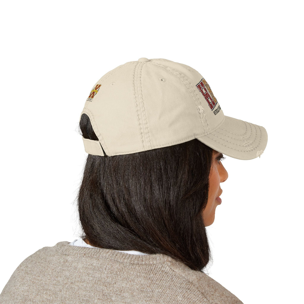 Creators Collection bone-colored distressed cotton cap with HBCU collegiate embroidery worn by a woman