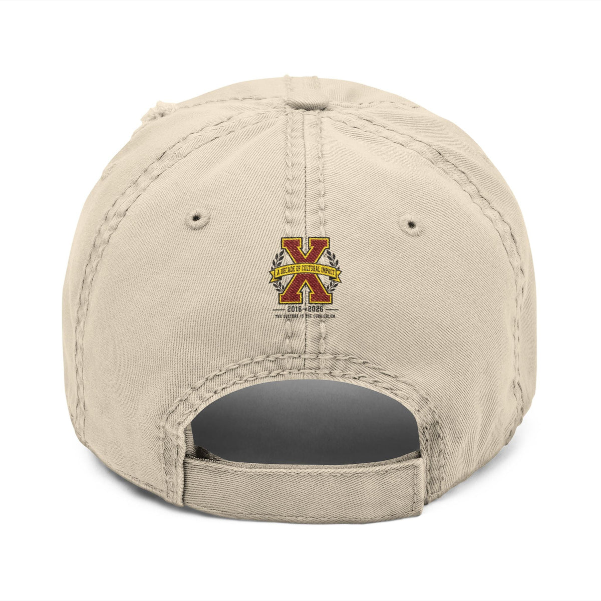 Creators Collection bone-colored distressed cotton cap featuring a tenth-anniversary X emblem on the back