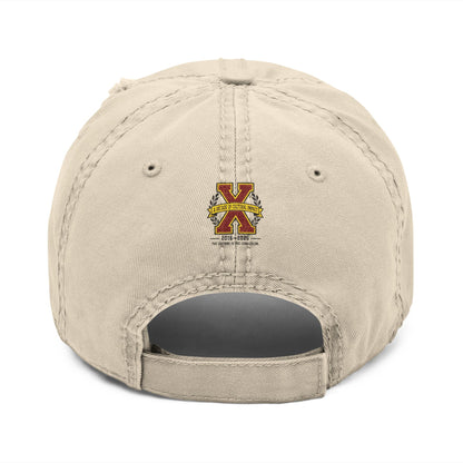 Creators Collection bone-colored distressed cotton cap featuring a tenth-anniversary X emblem on the back