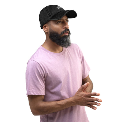 A bearded man wearing a Creators Collection black vintage cotton twill dad cap with intricate embroidery.